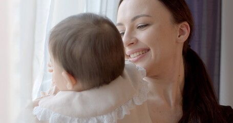 Verbal support, mental contact. The back of the child in the effect of bokeh contact with the mother. She smiles, says recognition in her daughter's ear.
