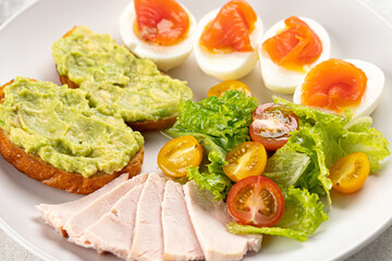 Healthy breakfast with eggs salmon and avocado toasts