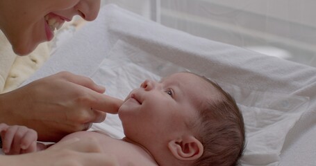 The mental bond between parent and child. Mother talking her newborn baby closeup. From birth baby...
