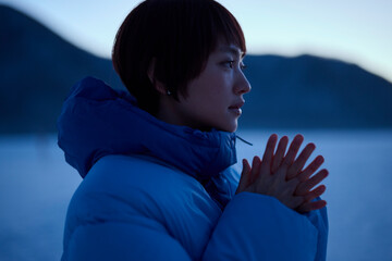 朝方,冬の山にいるショートヘアの女性