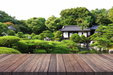 Wooden table top with blurred garden and japan house.	