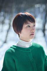 雪山 緑色のニットを着たショートヘアの女性