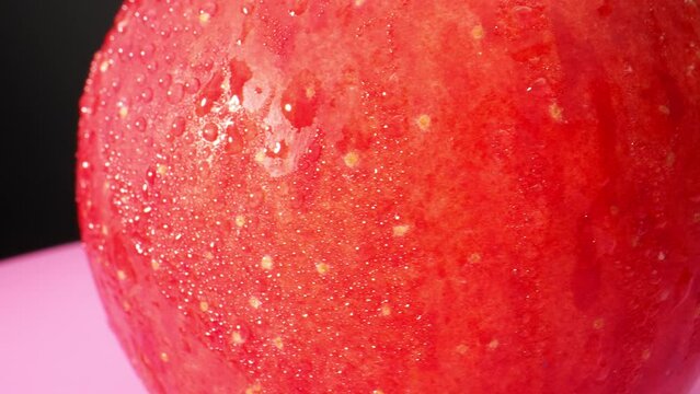 Water droplets on red apple in macro video, The probe lens, known for its unique and extreme close-up capabilities, Witness the minute intricacies that go unnoticed in everyday observation. 4K HDR
