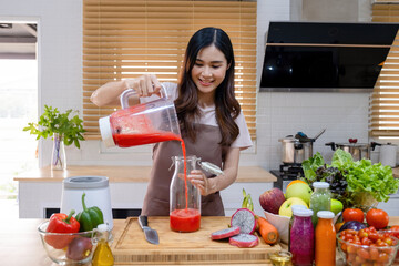 Woman making healthy smoothie using blender.