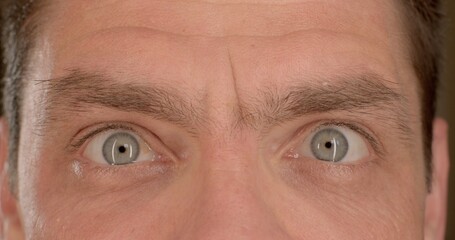 Eyebrows men face. Visual contact, blink, moisturize the body. Narrow pupil of the eye. Close-up of men's eyes blinking, looking intently into the camera. 