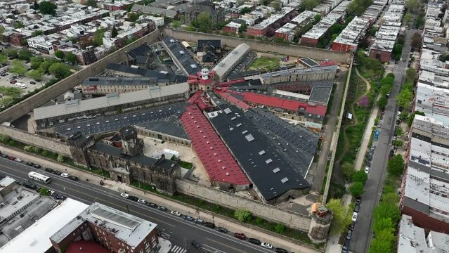 Aerial rotational shot of Eastern State Penitentiary in Philedelphia, PA. Famous historical prison open for educational tours in urban center. Jail, correctional facility theme.