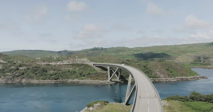 Panning drone shot of campervan driving over Kylesku Bridge along the west coast of scotland northcoast 500 route