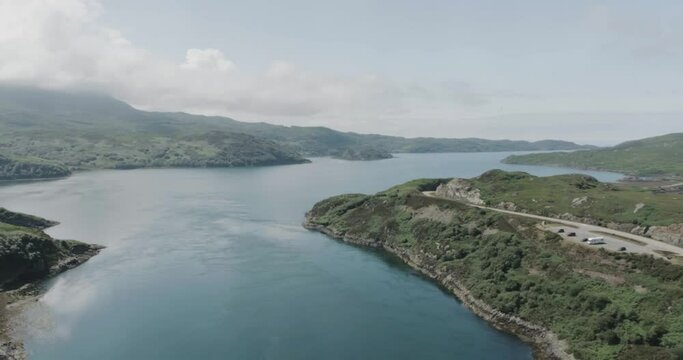 Wide drone shot of the Kylesku Bridge along scotland northcoast 500 route showing the mountain and sea terrain