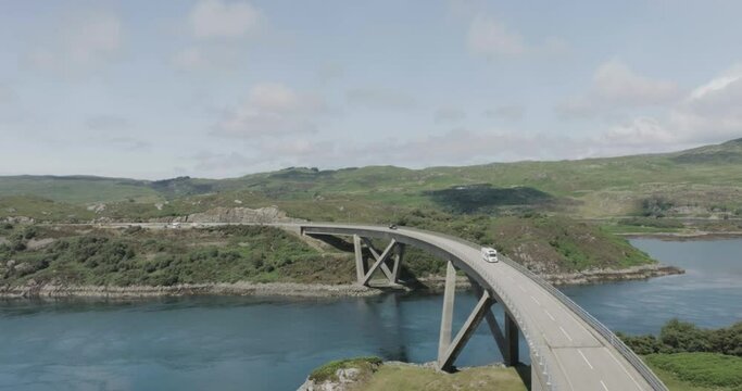 Static drone shot of campervan and motorbike driving over Kylesku Bridge along the west coast of scotland northcoast 500 route