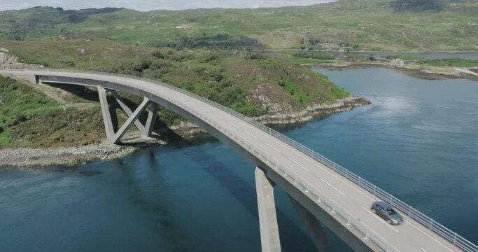 Static drone shot of a car travelling over Kylesku Bridge along scotland northcoast 500 route