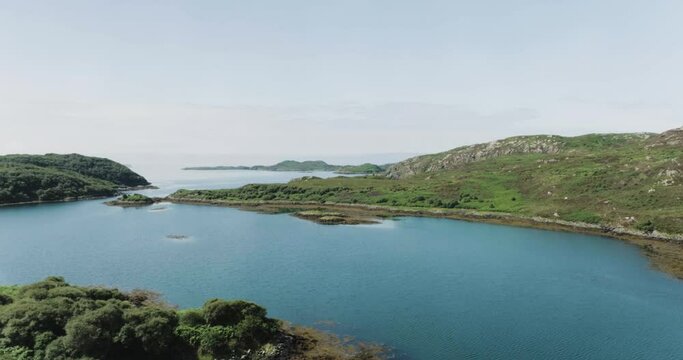 Slow push in drone shot showing small islands along scotland coastline looking out to sea