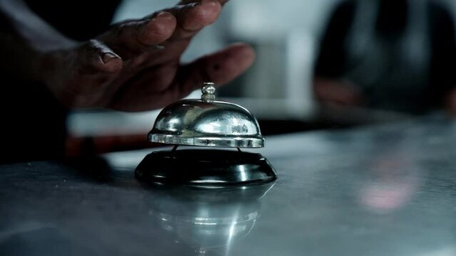 Staff at a restaurant rings the service bell