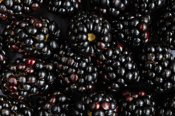 Background of fresh blackberries arranged together. Concept of healthy food and lifestyle. Macro photography of blackberries. Closeup view