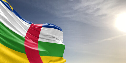 Central African Republic national flag cloth fabric waving on beautiful grey sky Background.