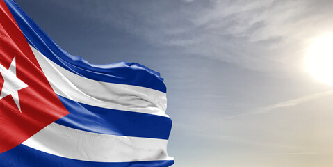 Cuba national flag cloth fabric waving on beautiful grey sky Background.