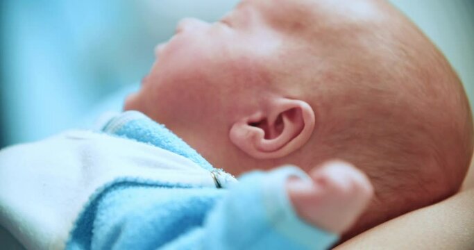 The smile of a little boy. The boy lies on his mother's lap for three months and looks into the camera. Beautiful baby with white skin color, European.