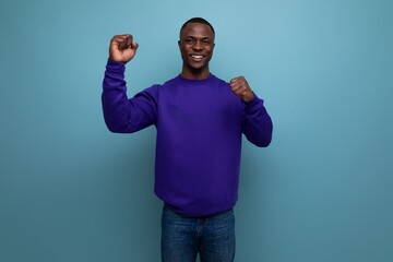 Fototapeta premium smiling modest young man living in America on a blue background with copy space