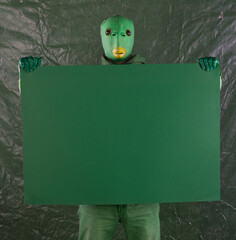 green alien with green poster