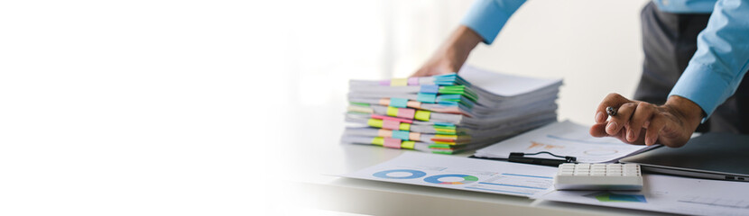 Businessman working on stacks of documents to search for information and check documents on office...