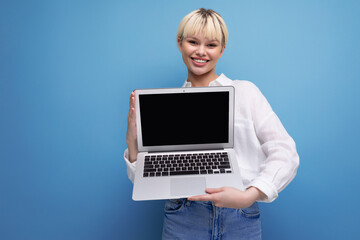 portrait of a smart confident young pretty blond secretary woman dressed in a white blouse demonstrating the screen of an open laptop with a mockup for advertising