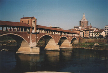 Fototapeta na wymiar View of Ancient Ponte Coperto Bridge on Ticino River. Pavia, Italy. Film Photography
