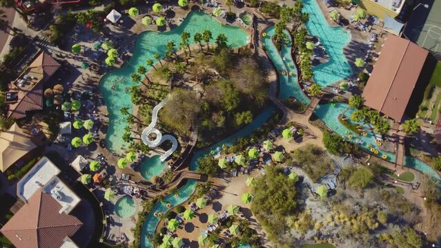 A top rotating drone captured a water park with people enjoying the various rides.
