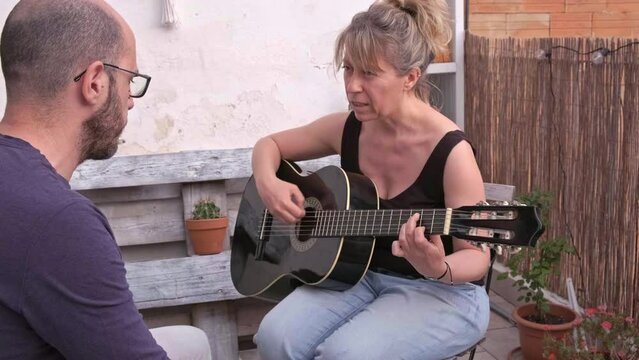 pareja de hombre y mujer cauc&aacute;sicos practican guitarra espa&ntilde;ola