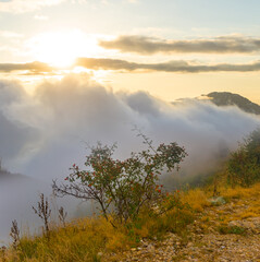 mount slope in dense mist and clouds at the sunset