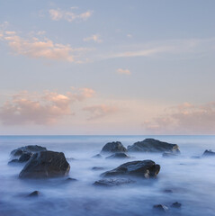 Fototapeta na wymiar sea coast with stones at the early morning, long exposure sea landscape