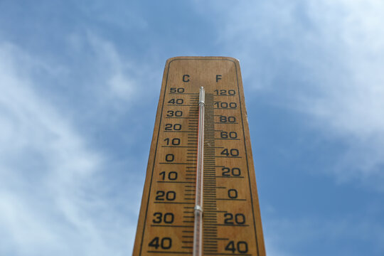 the thermometer shows a temperature of 39 degrees Celsius or 100 degrees Fahrenheit against a blue sky background during the day. bangka island temperature, global warming.