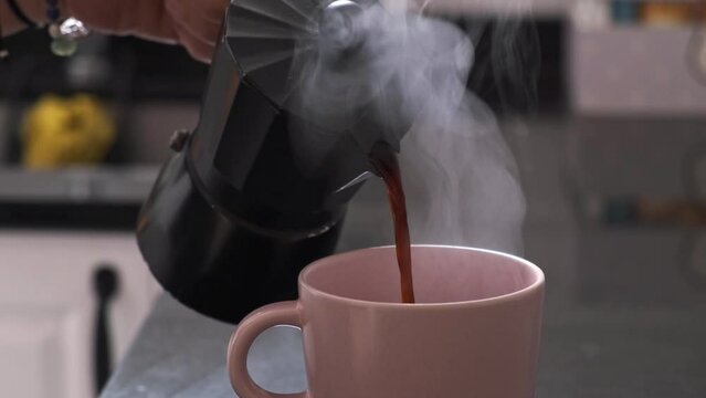serving fresh coffee in an italian moka pot in the morning, steaming hot and quality coffee
