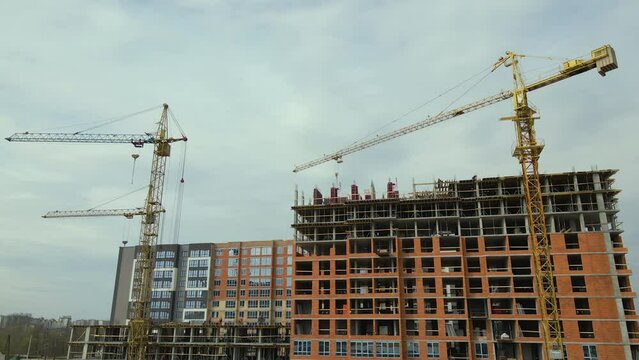 Tower lifting cranes at high residential apartment buildings construction site. Real estate development