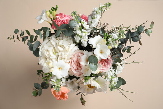 Bouquet of beautiful flowers on beige background, top view