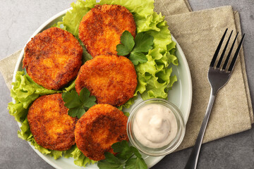Tasty vegan cutlets served with sauce on light grey table, top view