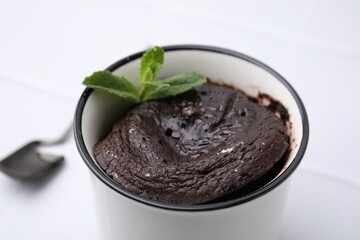 Tasty chocolate mug pie with mint on white background, closeup. Microwave cake recipe
