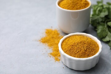 Aromatic curry powder on light grey table, closeup. Space for text