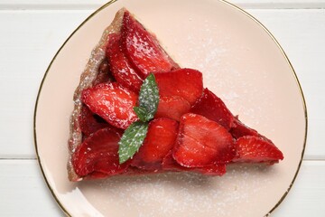 Piece of delicious strawberry tart with mint on white wooden table, top view