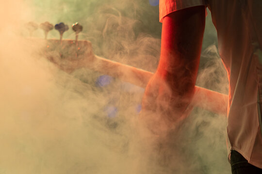 Bass guitar player in action in the stage  fog