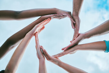 Diversity, collaboration and group of hands in a circle for unity, support and connection. Friends, synergy and multiracial people with round shape for community, solidarity and togetherness with sky