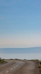 Fototapeta premium Vertical shot of a road with a sea in the background in Dalmatia, Croatia
