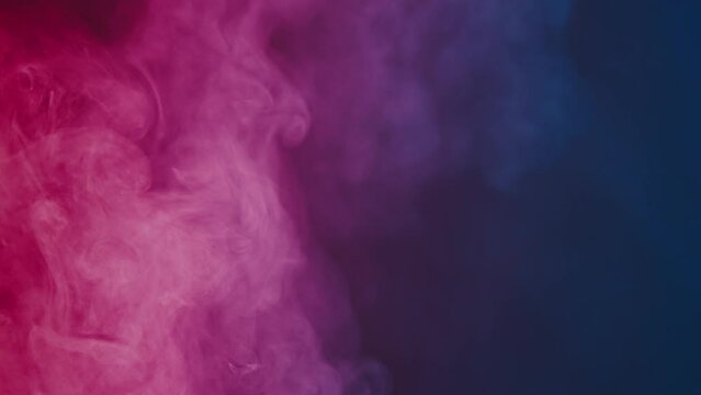 Fluffy clouds of smoke in blue pink neon light on a black background. Mockup for your logo, wallpaper or web banner. Slow motion.