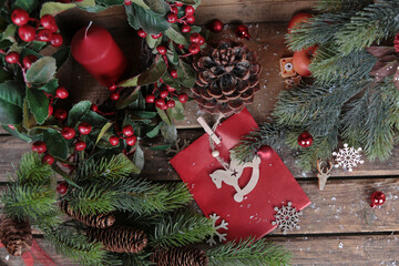 Weihnachten Geschenk und Dekoration mit Kerze, Tannenzapfen, Zweigen und roten Beeren - 605976935