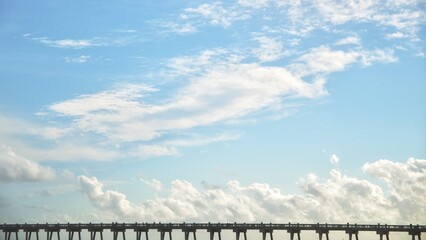 Obraz premium Bridge under the blue sky and white clouds