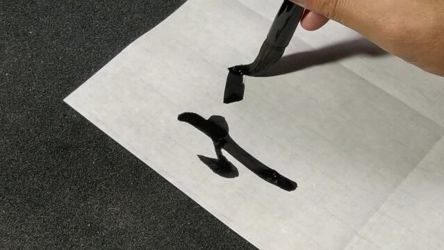 Writing Chinese Calligraphy Character translation:"Quick" on white paper.