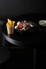 Greek salad and french fries on black table food