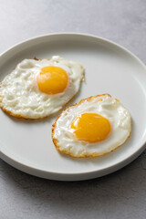 Fried eggs in a plate, food breakfast, healthy proteins. 