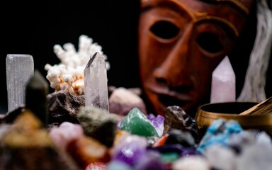 Healing mineral crystal stones and wooden african mask in the background