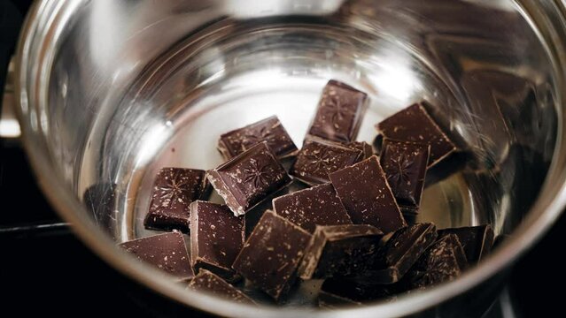 Slow-motion footage of chocolate bars in a pot for melting