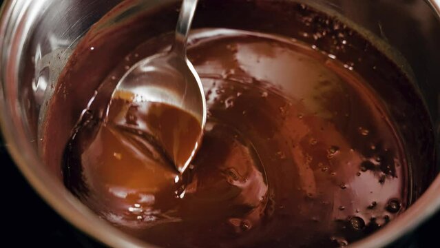 Slow-motion footage of melted chocolate in a pot