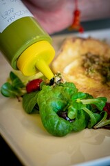 Closeup of pouring souce to greens